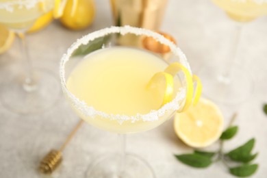 Photo of Delicious bee's knees cocktail on light grey table, closeup