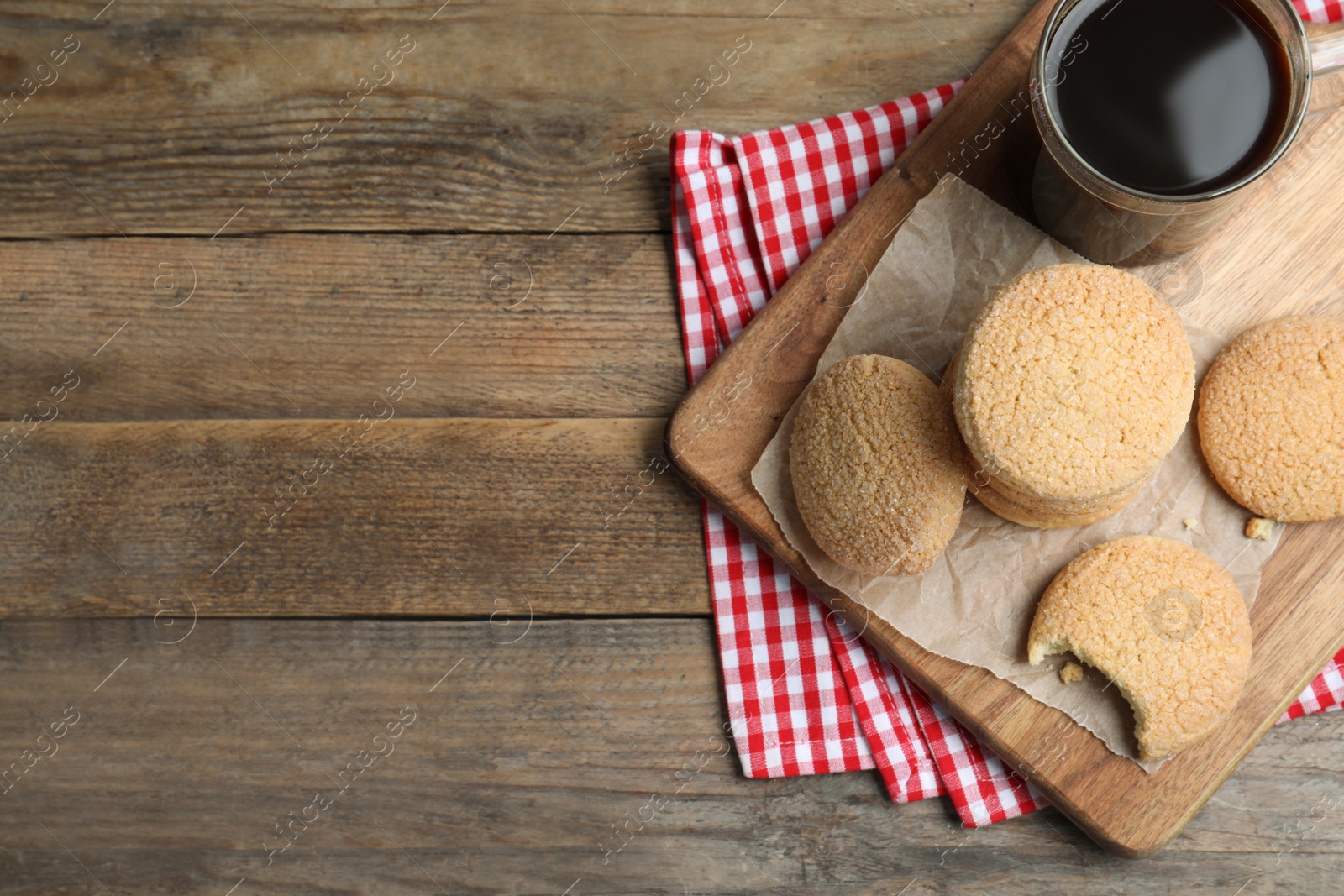 Photo of Delicious sugar cookies and cup of coffee on wooden table, flat lay. Space for text