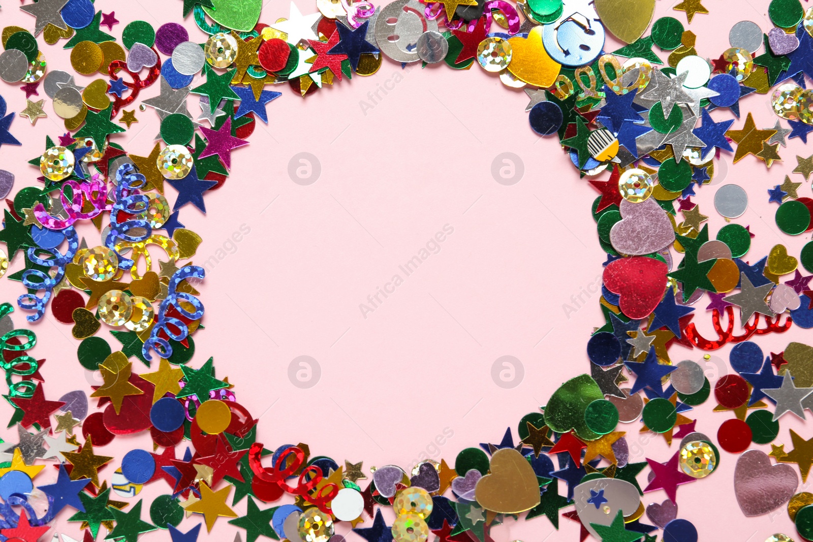 Photo of Frame made of bright confetti on pink background, flat lay. Space for text
