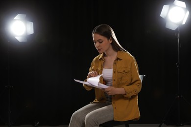 Professional actress reading her script during rehearsal in theatre