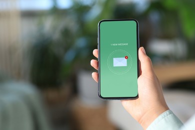 New message notification. Woman with mobile phone indoors, closeup