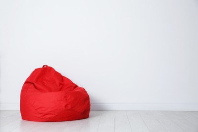 Photo of Red bean bag chair near white wall in room
