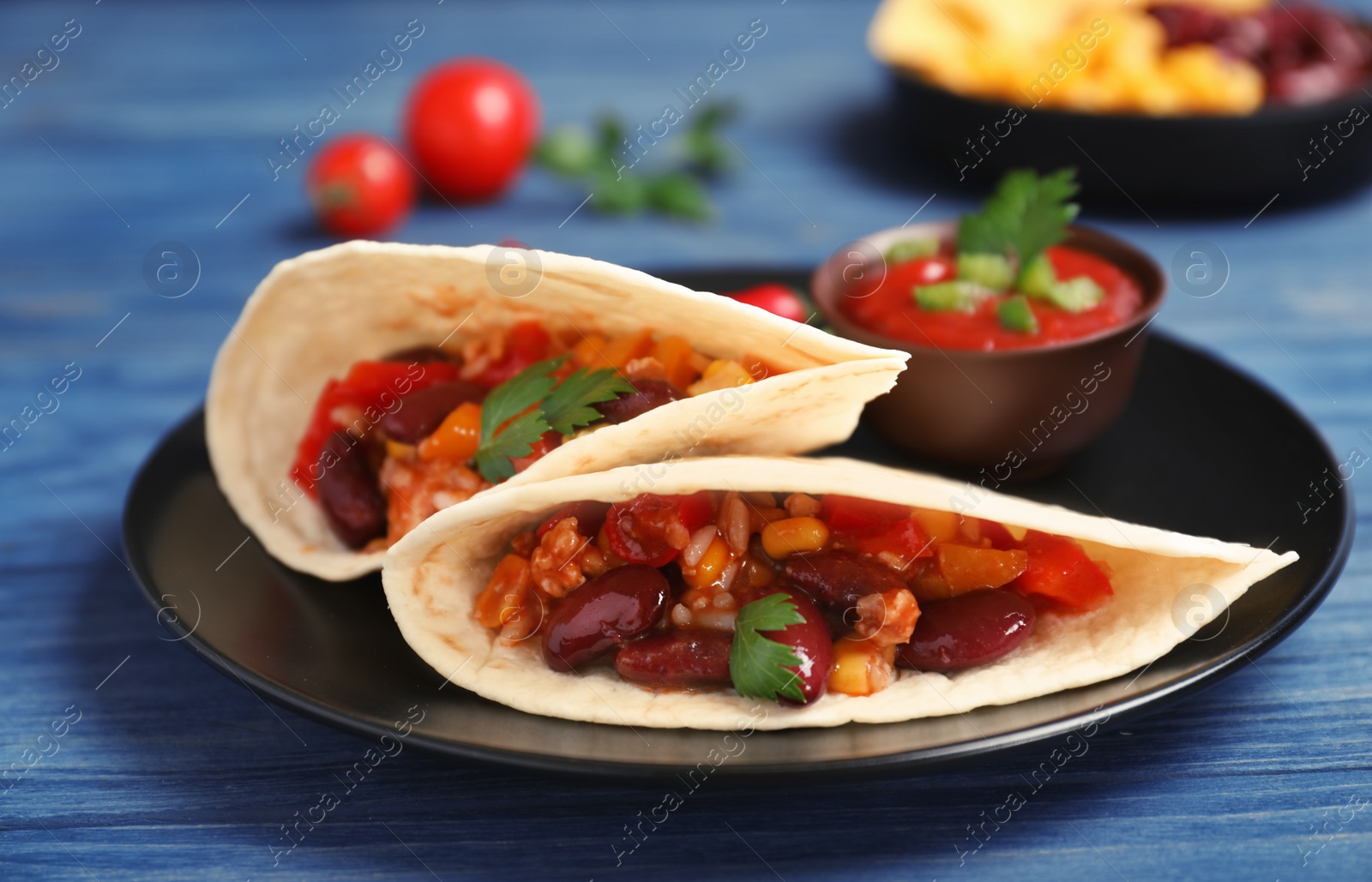 Photo of Chili con carne served with tortilla on table