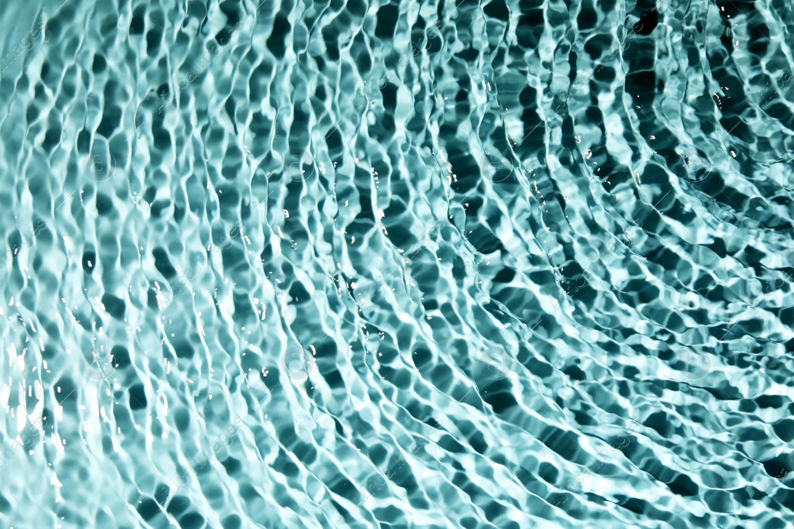 Photo of Closeup view of water with rippled surface on light blue background