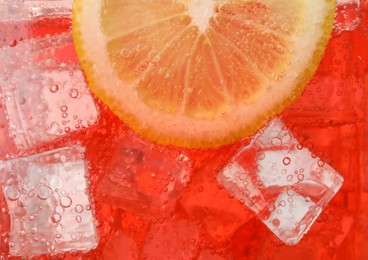 Closeup view of cold refreshing drink with ice and lemon slice in glass