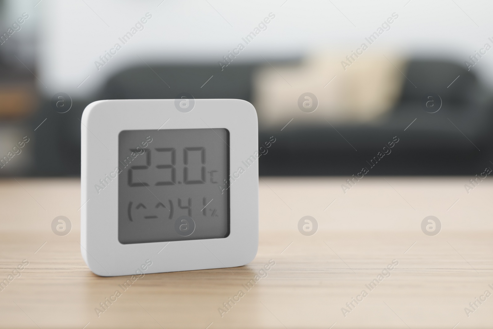 Photo of Digital hygrometer with thermometer on wooden table indoors, closeup. Space for text