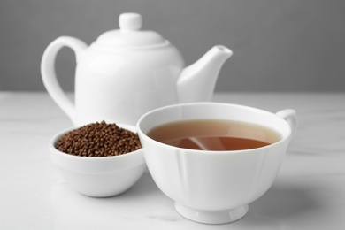 Photo of Delicious buckwheat tea and granules on white table