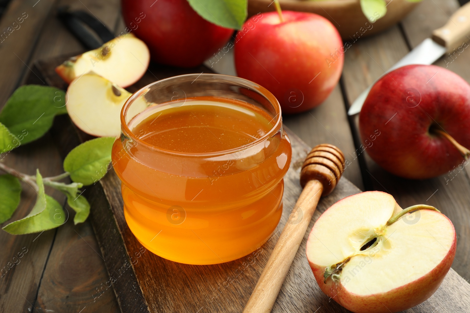 Photo of Sweet honey and fresh apples on wooden table, closeup