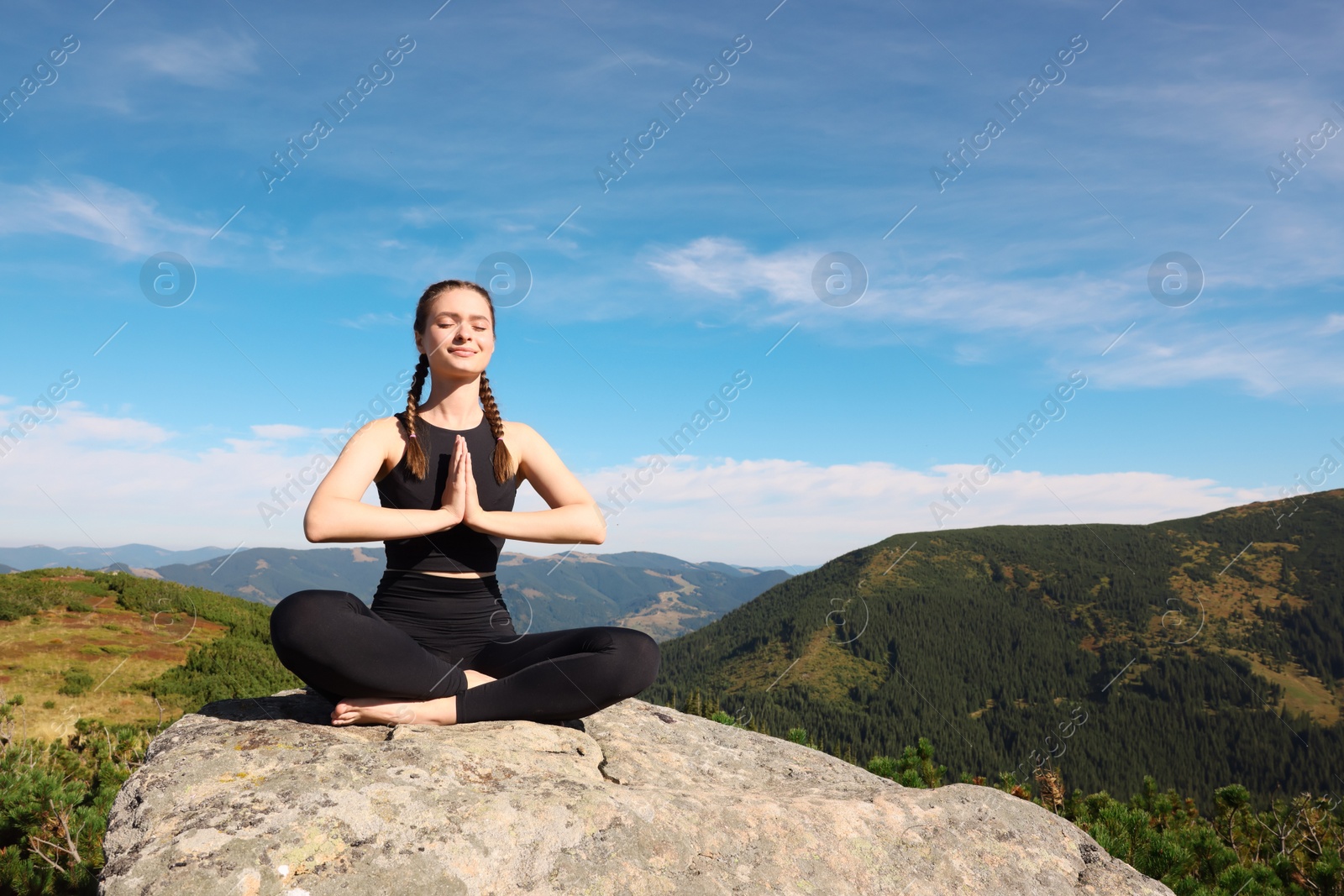 Photo of Young woman practicing outdoor yoga in mountains, space for text. Fitness lifestyle