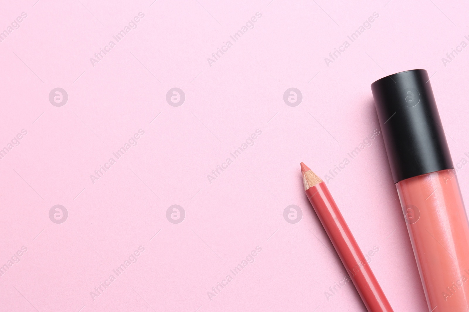 Photo of Bright lip pencil and liquid lipstick on pink background, flat lay with space for text. Cosmetic products
