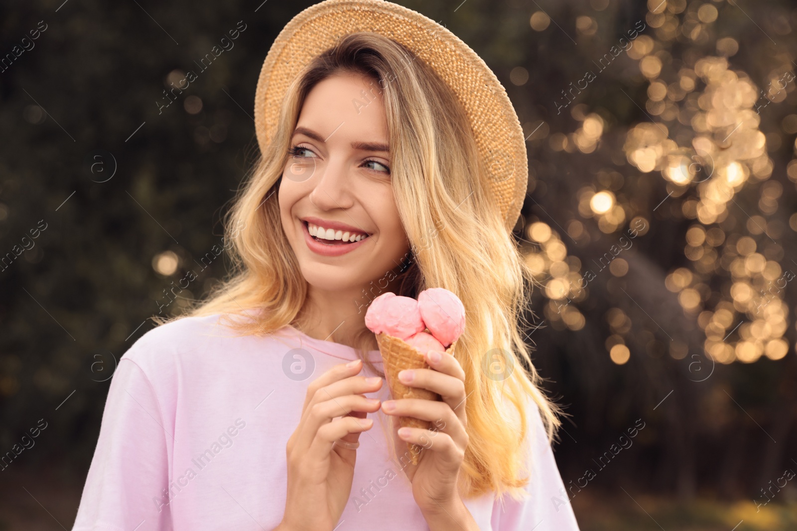 Photo of Happy young woman with delicious ice cream in waffle cone outdoors