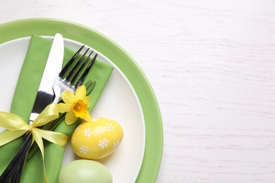 Photo of Festive Easter table setting with eggs on white wooden background, top view. Space for text