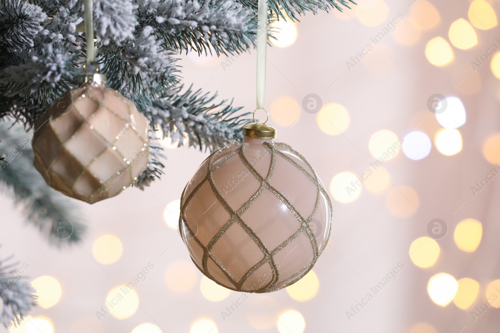 Photo of Christmas tree decorated with holiday baubles against blurred lights, closeup