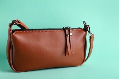 Photo of Stylish brown woman's bag on turquoise background
