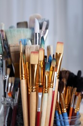Photo of Closeup view of many different paintbrushes indoors