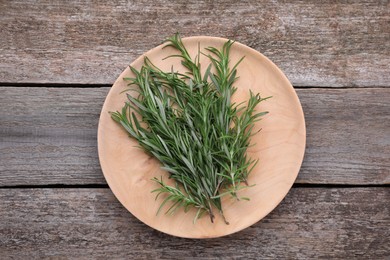 Photo of Sprigs of fresh rosemary on wooden table, top view