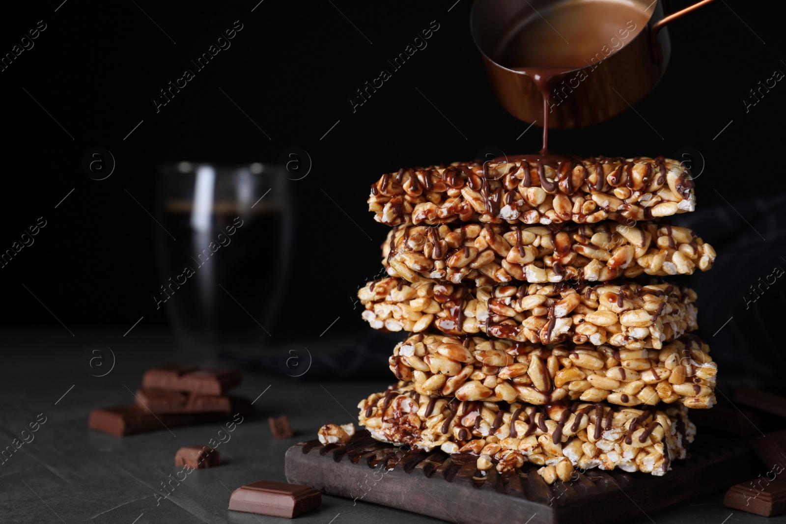 Photo of Delicious rice crispy treats on black table. Space for text