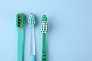 Photo of Many different toothbrushes on light blue background, flat lay. Space for text