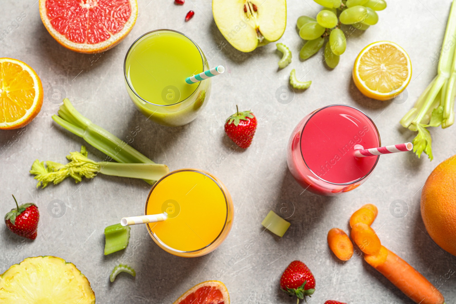 Photo of Flat lay composition with different glasses of juices and fresh ingredients on light background