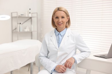 Portrait of happy dermatologist in modern clinic