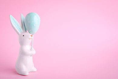 Easter bunny figure on pink background. Space for text