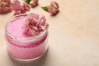 Aromatic sea salt and flowers on beige textured table, closeup. Space for text