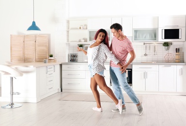 Photo of Beautiful couple dancing in kitchen at home