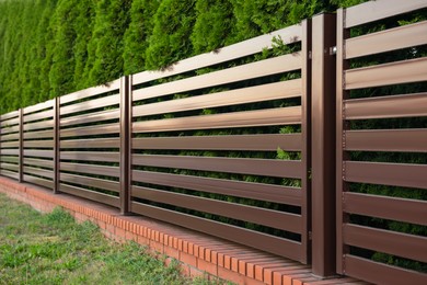 Photo of Beautiful fence with brick and brown iron railing