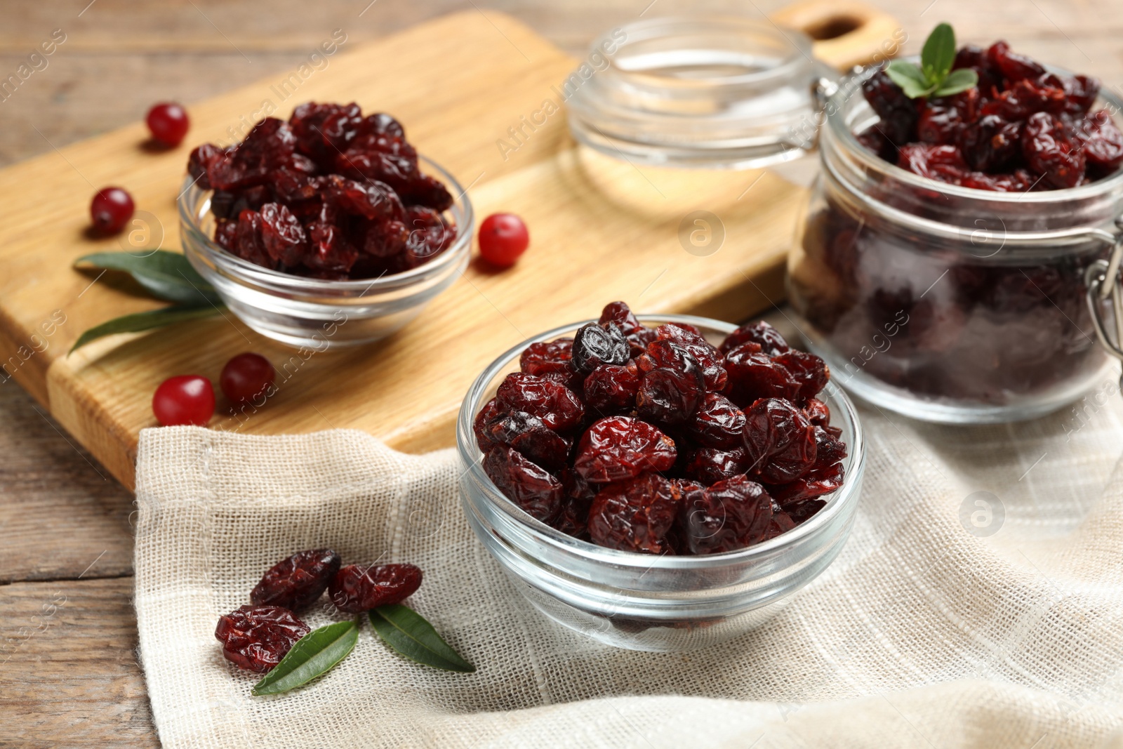 Photo of Tasty dried cranberries and leaves on table