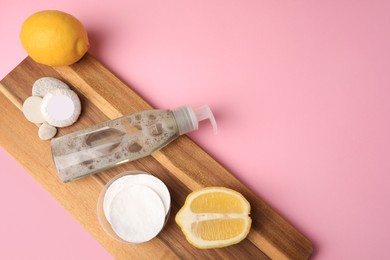 Photo of Lemon face cleanser. Fresh citrus fruits and personal care products on pink background, flat lay with space for text