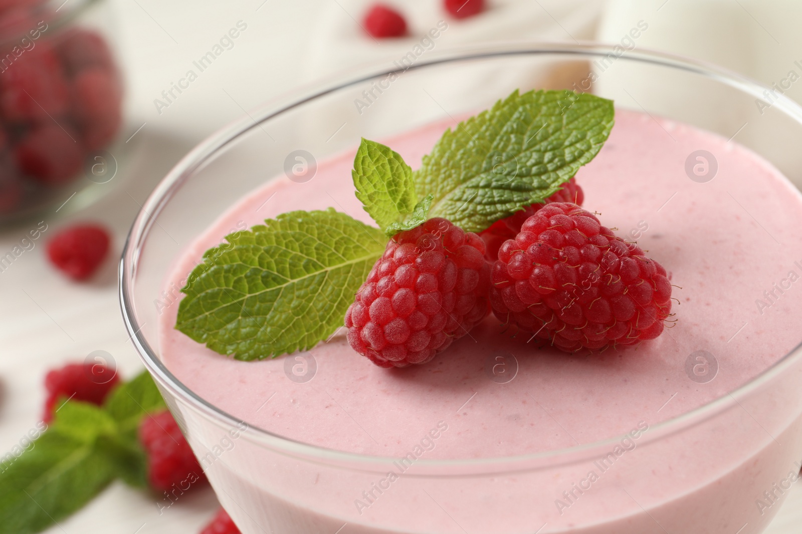 Photo of Glass of delicious raspberry mousse with mint, closeup