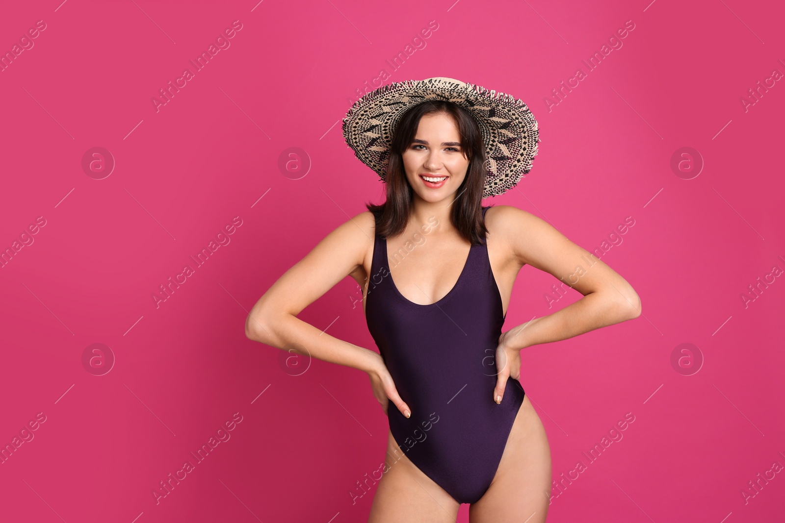 Photo of Beautiful woman in stylish swimsuit and hat on pink background