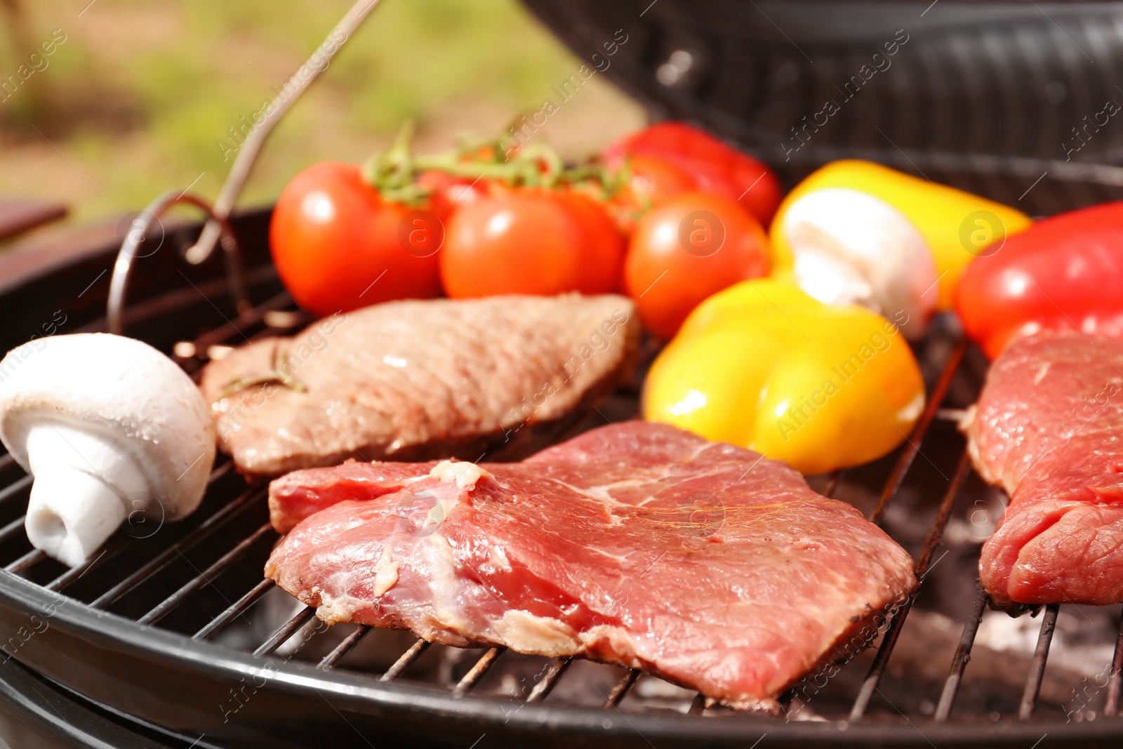 Photo of Modern grill with meat and vegetables outdoors, closeup