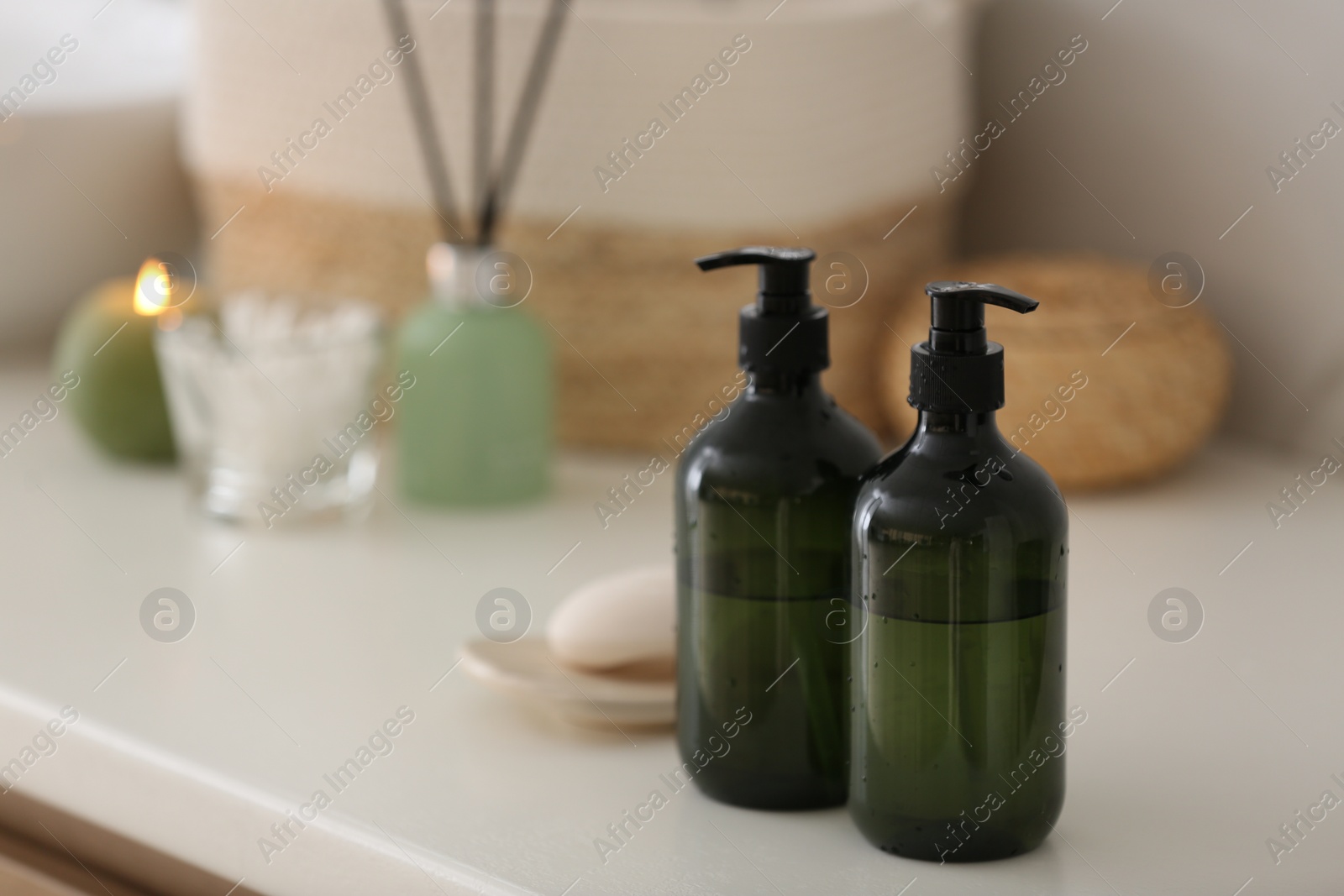 Photo of Green soap dispensers on white countertop in bathroom. Space for text