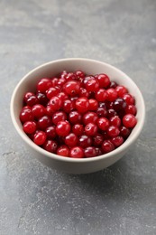 Photo of Fresh ripe cranberries in bowl on grey table