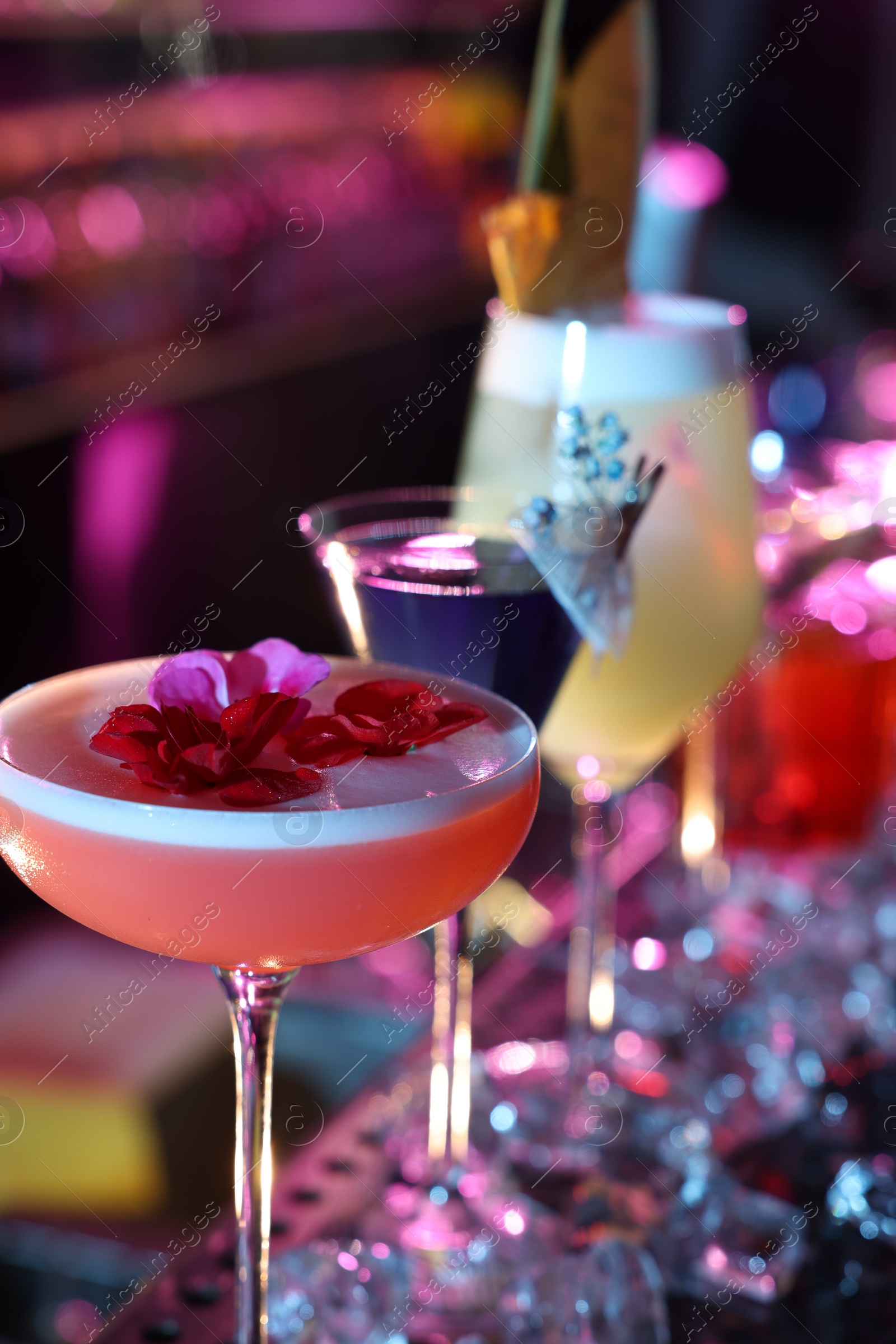 Photo of Different fresh alcoholic cocktails on counter in bar