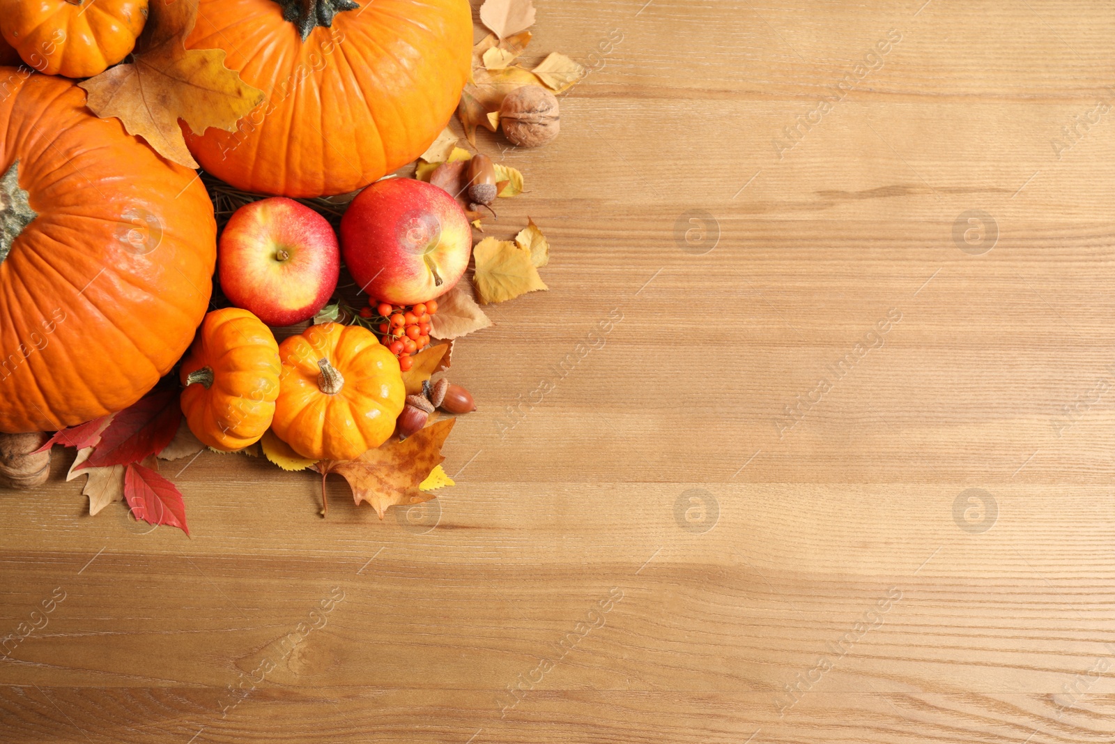 Photo of Flat lay composition with ripe pumpkins and autumn leaves on wooden table, space for text. Happy Thanksgiving day