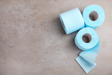 Photo of Toilet paper rolls on grey background, top view. Space for text