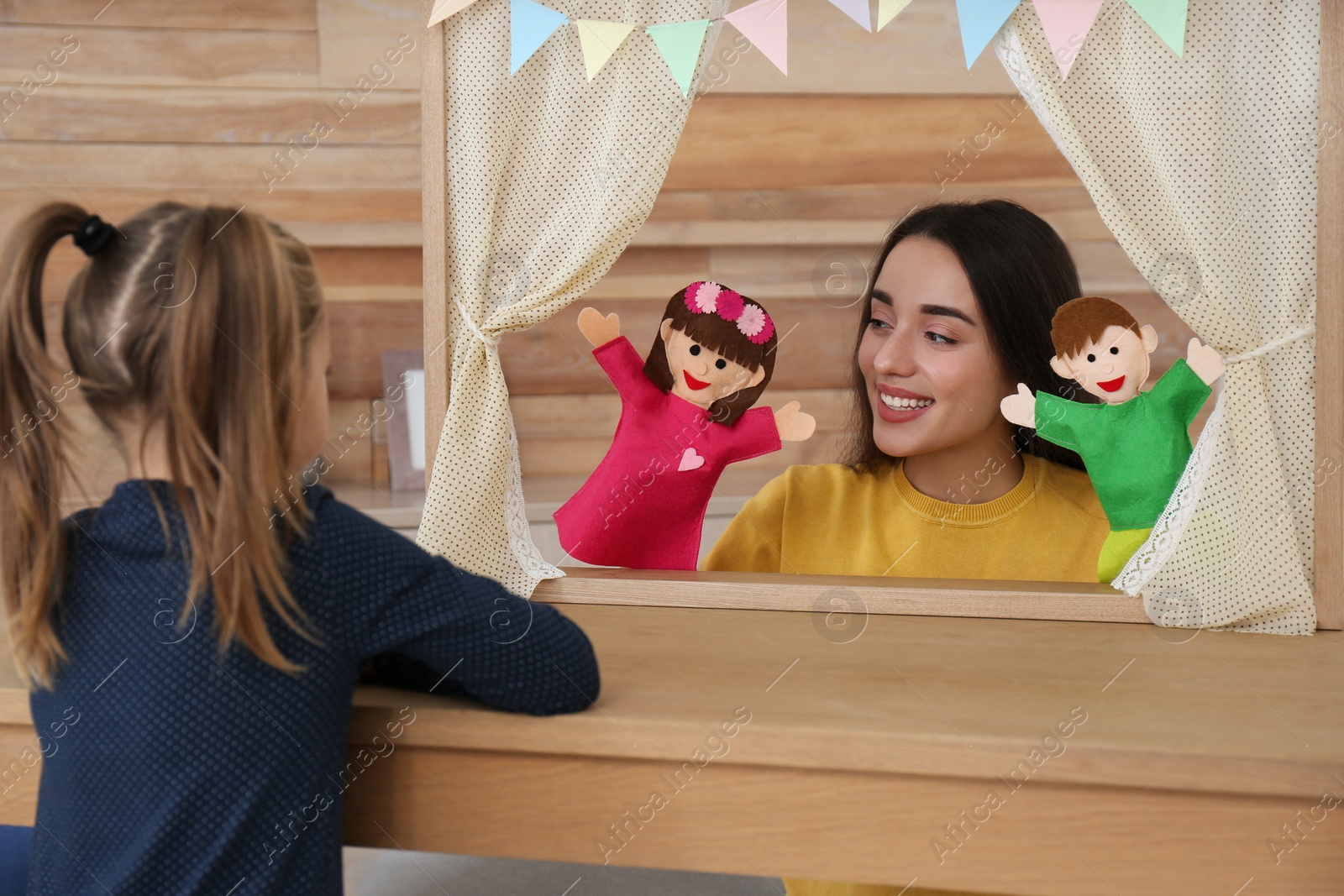 Photo of Mother performing puppet show for her daughter at home