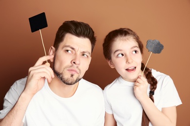 Photo of Dad and his daughter having fun on color background. Father's day celebration