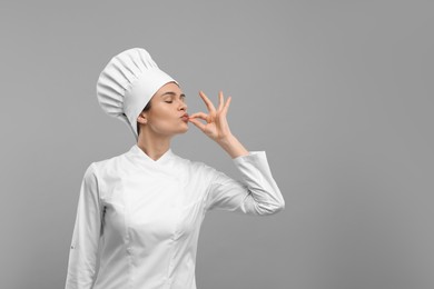 Photo of Female chef showing perfect sign on light grey background