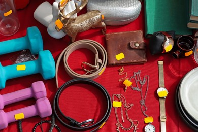 Photo of Many different items on table outdoors, above view. Garage sale