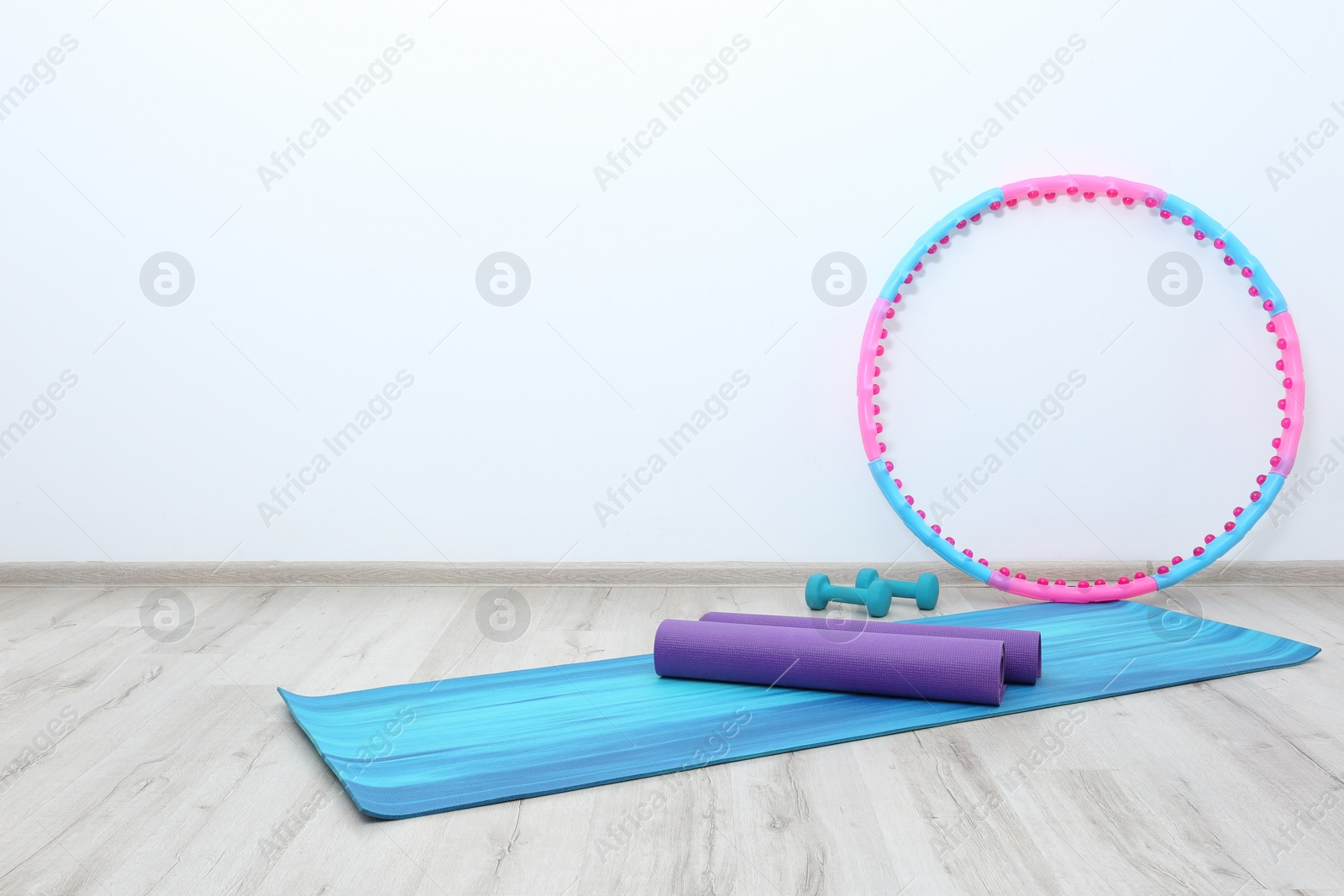 Photo of Hula hoop, yoga mats and dumbbells in physiotherapy gym