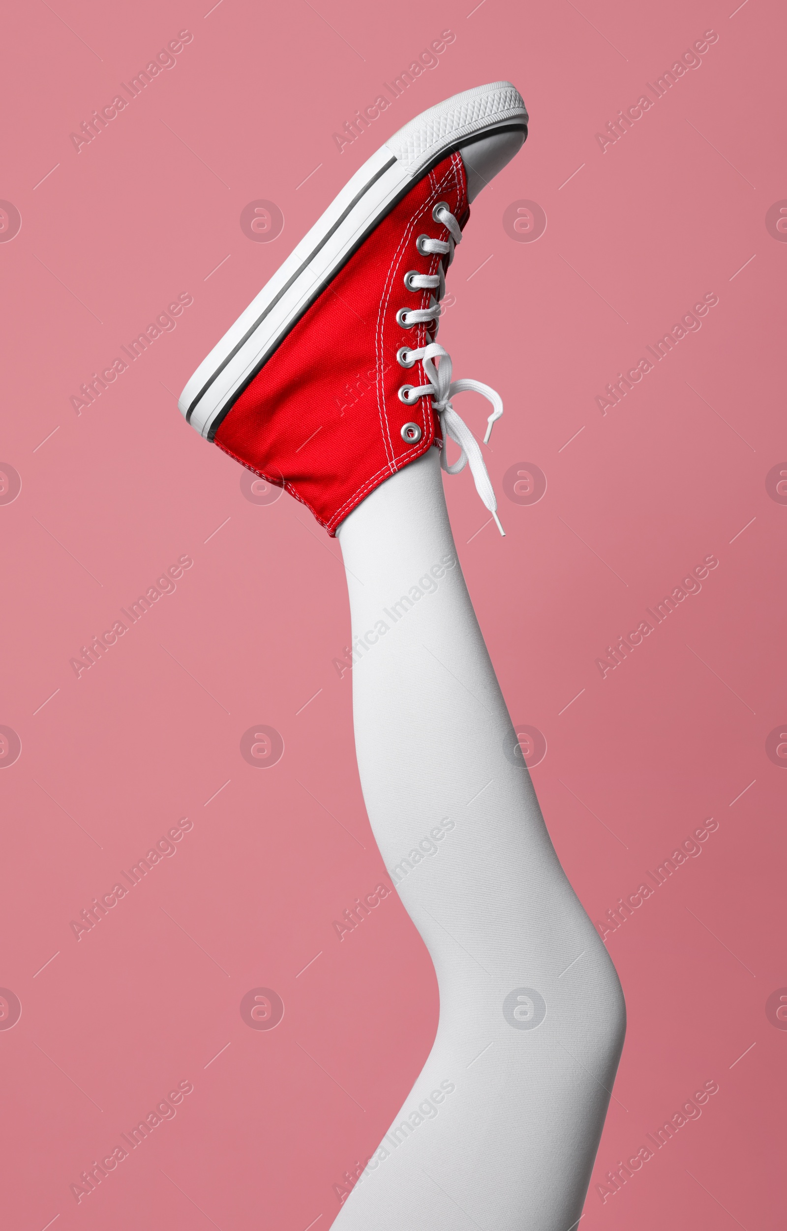 Photo of Woman wearing shoes on pink background, closeup