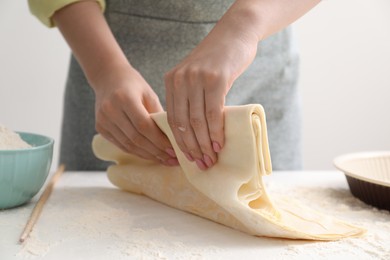 Photo of Making tasty baklava. Woman with dough at table, closeup