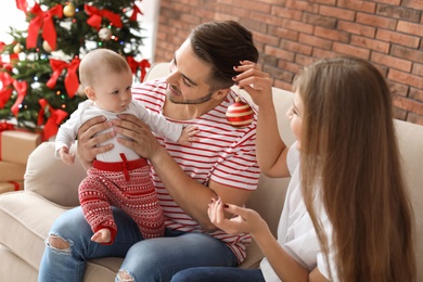 Happy couple with baby celebrating Christmas together at home