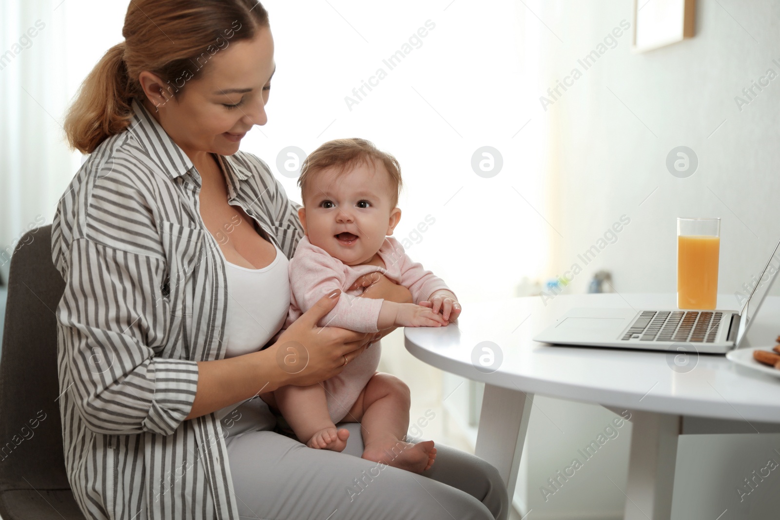 Photo of Young woman with her cute baby at home