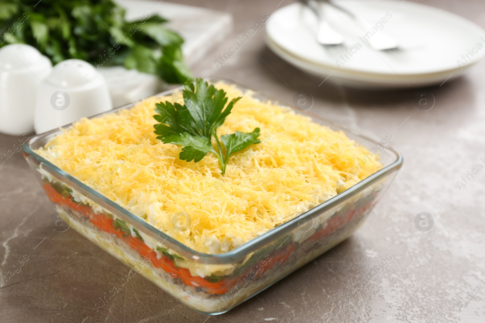 Photo of Traditional russian salad Mimosa served on marble table