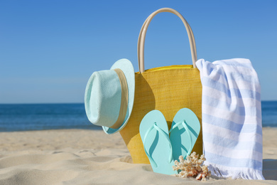 Stylish beach accessories for summer vacation on sand near sea