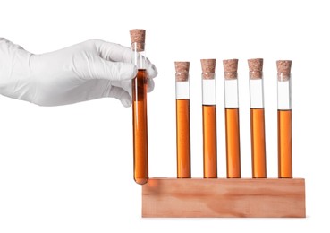 Photo of Scientist taking test tube with brown liquid from stand on white background, closeup
